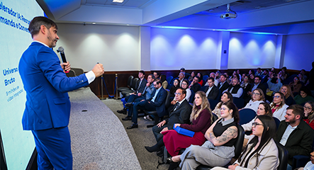 Palestrante apresenta conteúdo para público em auditório durante evento.
