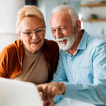 Casal de idosos olhando para o computador