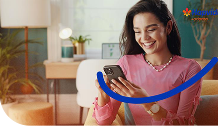 Mulher sorrindo olhando para o celular que esta em mãos